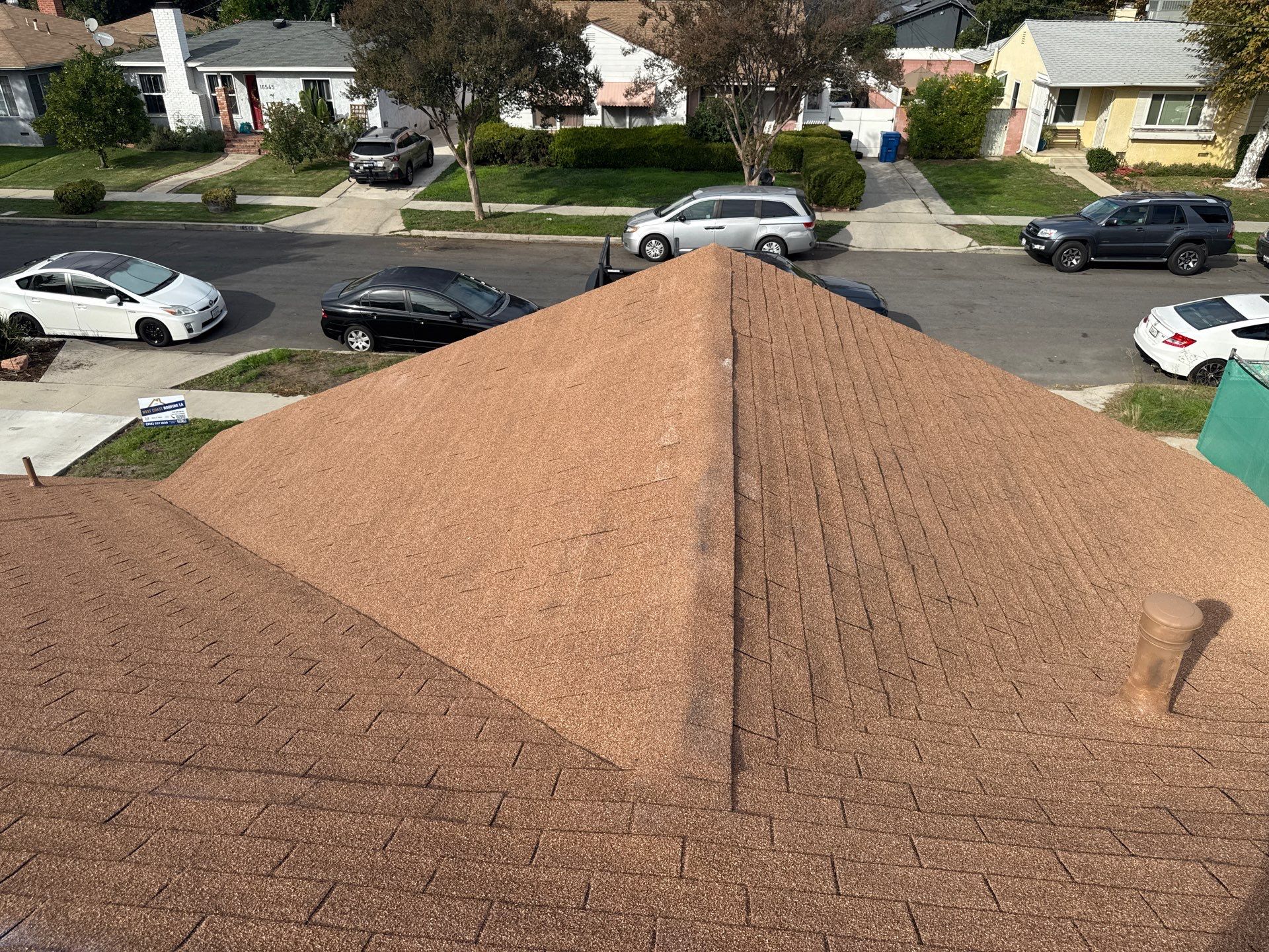 Professional roofer checking roof flashing and drainage on multi-story coastal property