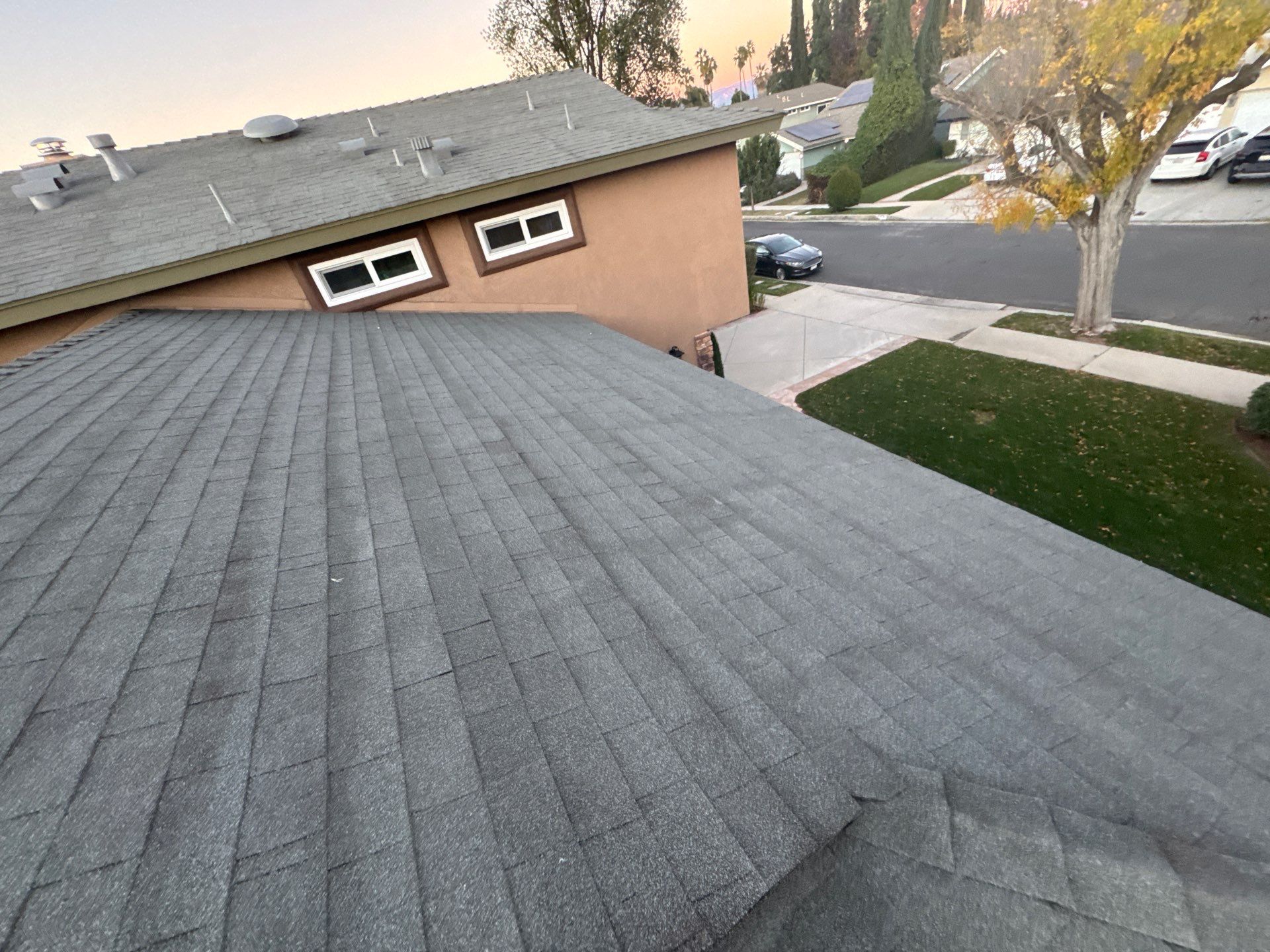 Crew removing worn shingles before installing new residential roof in Van Nuys