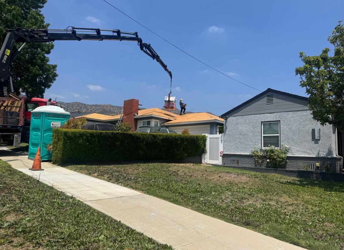 Licensed roofer performing safety inspection on high-pitched roof using professional tools in Sherman Oaks, CA