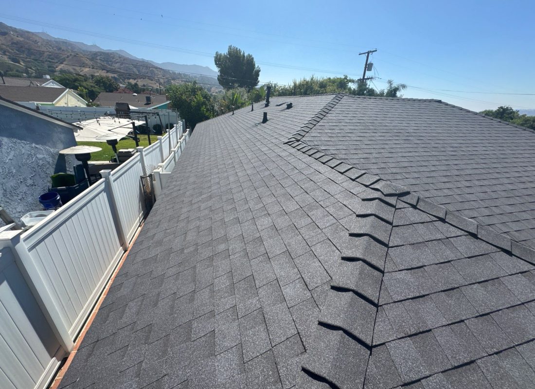 Experienced roofer performing roof tear-off with safety gear on a two-story Glendale home