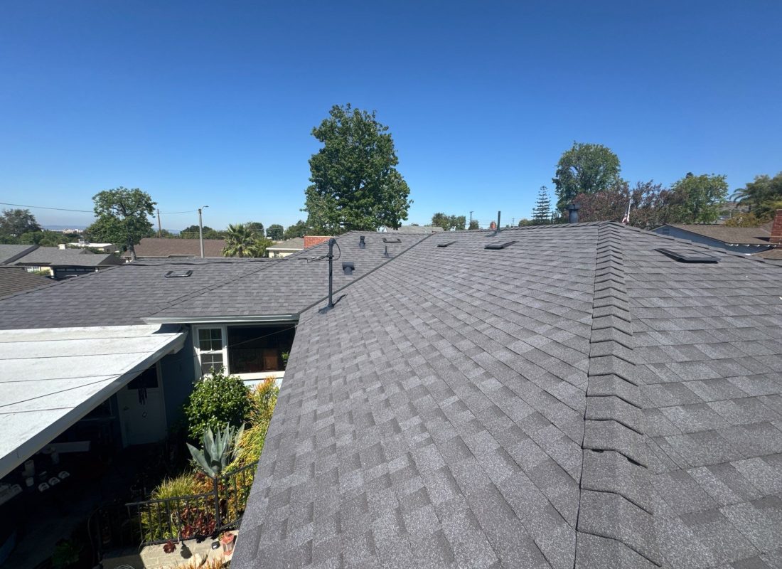 Roofing crew replacing worn shingles on coastal home near Santa Monica shoreline
