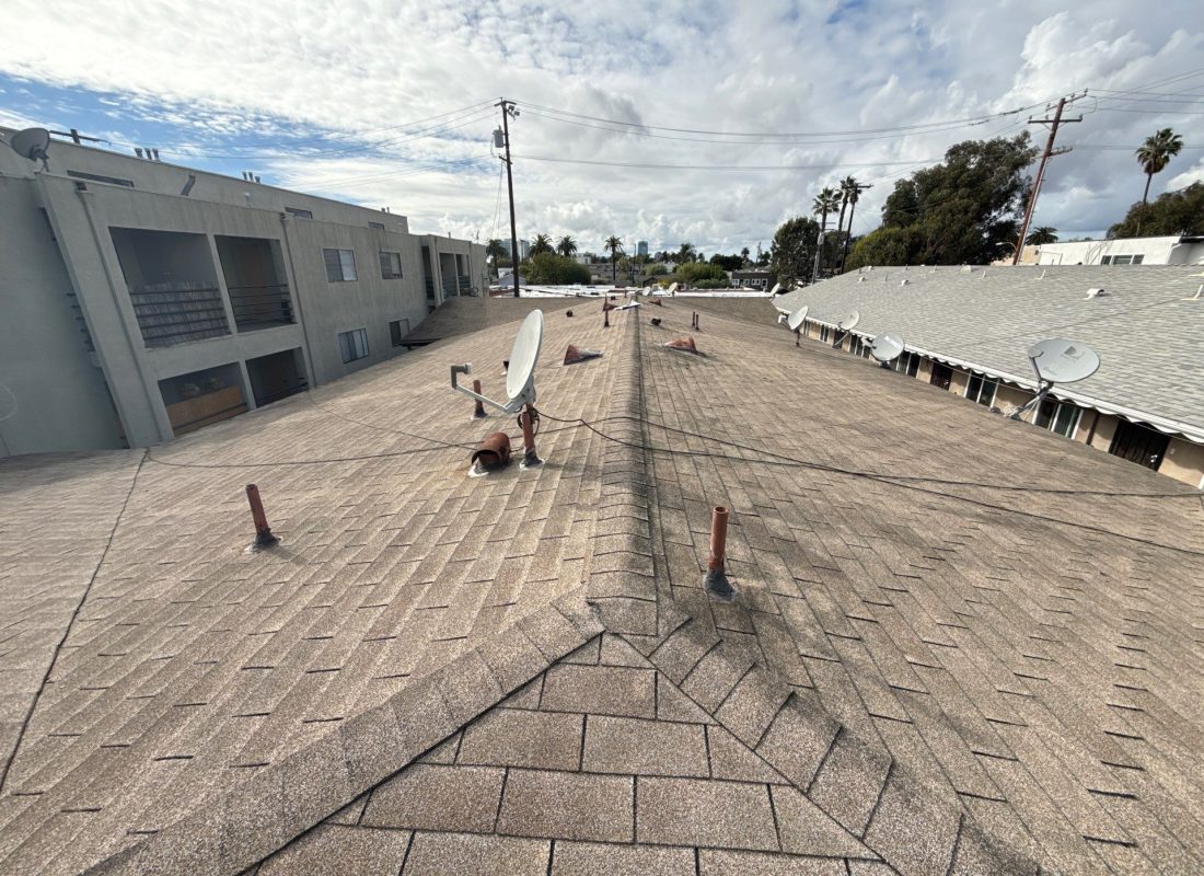 Roofing crew safely replacing shingles on a residential Sherman Oaks, CA home during a scheduled roof upgrade