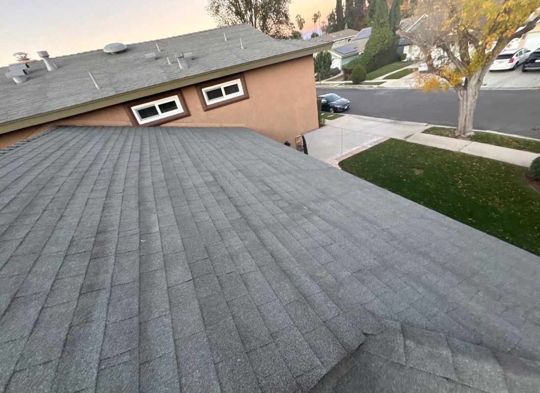 Roofing crew installing premium shingles on upscale Beverly Hills, CA home with palm trees in background