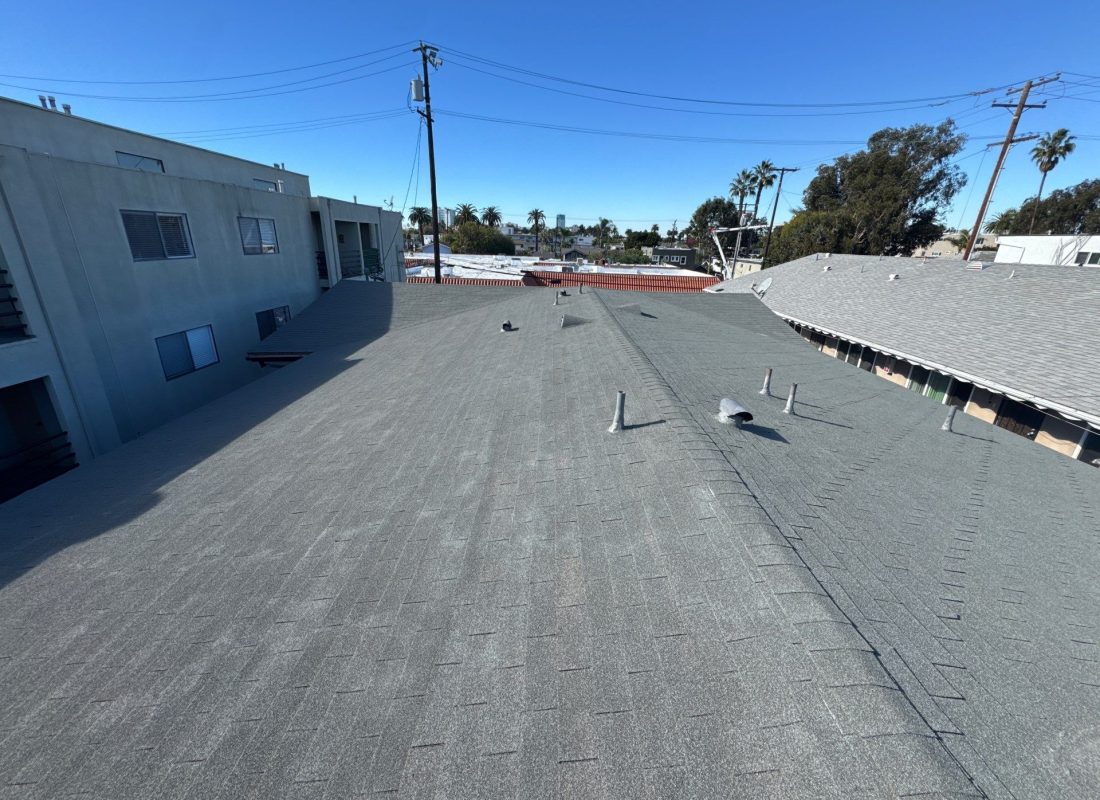 Technician performing roofing services on a Burbank, CA home while checking vent and flashing condition